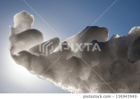 A mass of melted snow that has taken on a sculptural shape A mass of melted snow that has taken on a sculptural shape 136943949