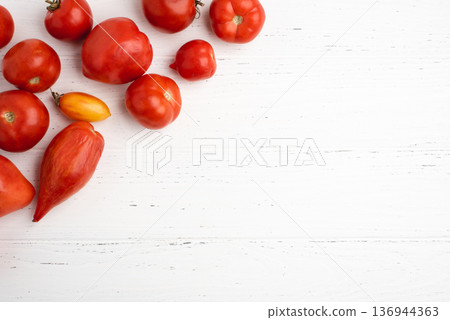 Fresh harvest of red tomatoes on a white wooden table. 136944363