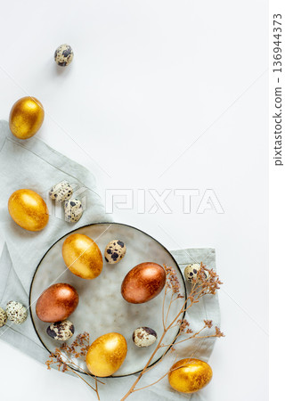 Golden and bronze Easter eggs in a gray plate 136944373