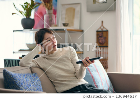 A woman watching TV at home A woman watching TV at home 136944617