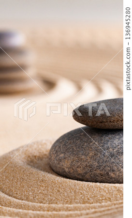 Stacked stones on sand with ripples in a zen garden during daylight hours 136945280