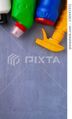 Bottles of cleaning products on a gray surface during daylight hours in a home setting 136945352