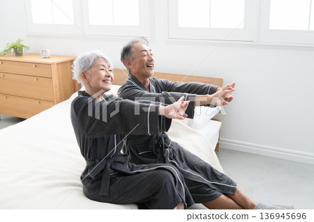 一對老年夫婦穿著長袍坐在床上，生活方式圖片 136945696