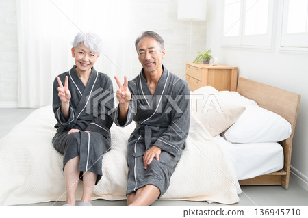 一對老年夫婦穿著長袍坐在床上,生活方式圖片 一對老年夫婦穿著長袍坐在床上,生活方式圖片 136945710