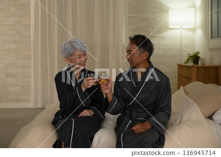 一對老年夫婦穿著長袍坐在床上,生活方式圖片 一對老年夫婦穿著長袍坐在床上,生活方式圖片 136945714