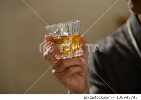 Senior man wearing a gown and holding a rocks glass Lifestyle image Senior man wearing a gown and holding a rocks glass Lifestyle image 136945745