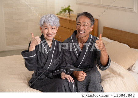 一對老年夫婦穿著長袍坐在床上,生活方式圖片 一對老年夫婦穿著長袍坐在床上,生活方式圖片 136945948