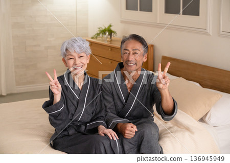 一對老年夫婦穿著長袍坐在床上，生活方式圖片 136945949