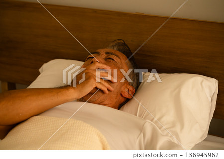 Senior man sleeping in bed Lifestyle image Senior man sleeping in bed Lifestyle image 136945962