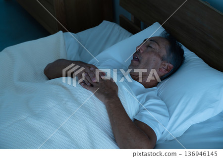 Senior man sleeping in bed Lifestyle image 136946145