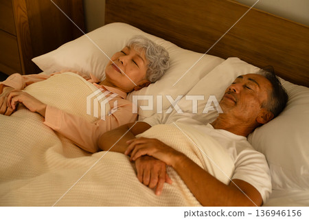 Senior couple sleeping in bed Lifestyle image Senior couple sleeping in bed Lifestyle image 136946156