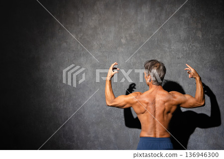 一位老年男子赤裸上身,擺出健美姿勢。運動圖片 一位老年男子赤裸上身,擺出健美姿勢。運動圖片 136946300