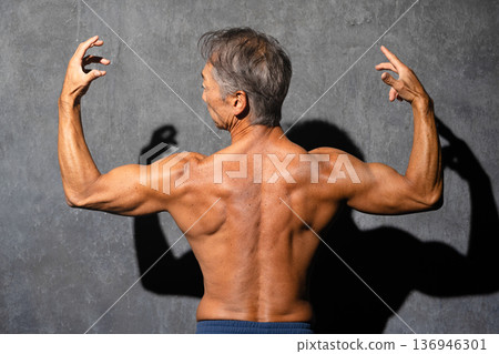 一位老年男子赤裸上身,擺出健美姿勢。運動圖片 一位老年男子赤裸上身,擺出健美姿勢。運動圖片 136946301