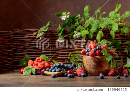 Berries closeup colorful assorted mix of strawberry, blueberry, raspberry and sweet cherry on a old wooden table. Berries closeup colorful assorted mix of strawberry, blueberry, raspberry and sweet cherry on a old wooden table. 136946515