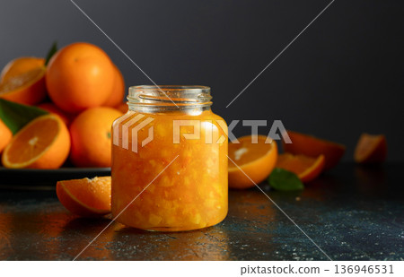 Orange jam and fresh fruits on a dark blue table. Orange jam and fresh fruits on a dark blue table. 136946531
