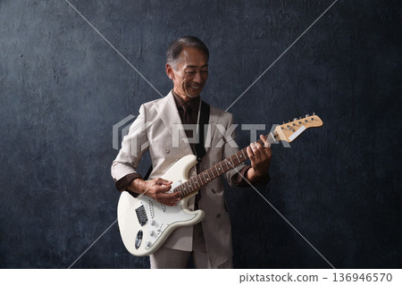 Senior man playing guitar lifestyle image Senior man playing guitar lifestyle image 136946570