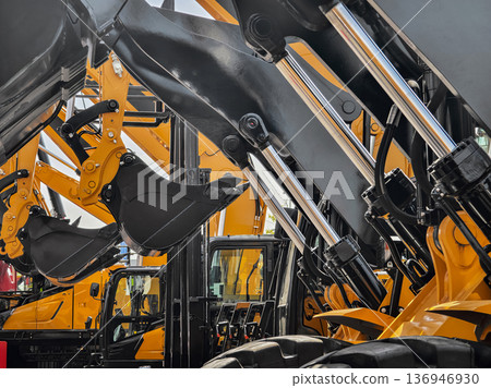 Construction equipment lined up at a dealership showing loaders and excavators ready for work in the afternoon sun 136946930