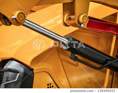 Close-up view of hydraulic system in construction vehicle showing details of machinery and components in use at a work site 136946933