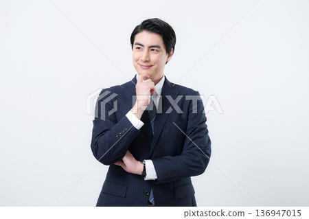 Standing handsome middle-aged businessman, upper body, smiling, thinking, worried, hand on chin, looking up Standing handsome middle-aged businessman, upper body, smiling, thinking, worried, hand on chin, looking up 136947015