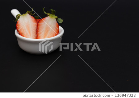 鮮紅色草莓的白色橫切面。草莓的庫存照片，背景為黑色。 136947328