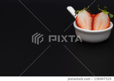 鮮紅色草莓的白色橫切面。草莓的庫存照片，背景為黑色。 136947329