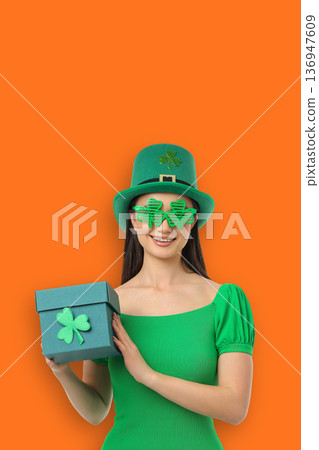 A girl in a green outfit holds a gift box for St. Patrick's Day A girl in a green outfit holds a gift box for St. Patrick's Day 136947609
