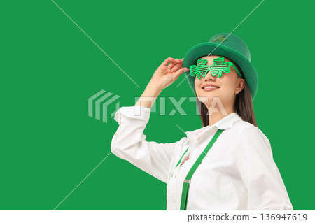 A smiling woman in green glasses and a hat celebrates A smiling woman in green glasses and a hat celebrates 136947619