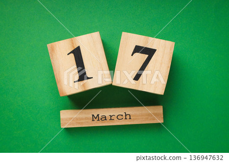 Wooden blocks showing the date March 17 on green backdrop 136947632