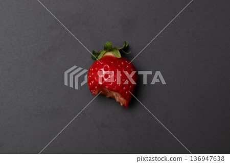一顆鮮紅的草莓正在被吃掉 一顆鮮紅的草莓正在被吃掉 136947638