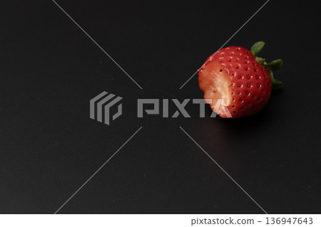 一顆鮮紅的草莓正在被吃掉 一顆鮮紅的草莓正在被吃掉 136947643