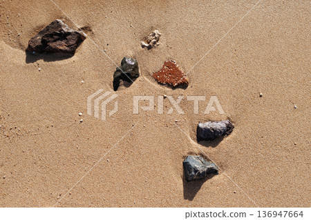 Sea stones on the sand. Beautiful tidal waves on the beach. Sandy beach of the Red Sea. Egypt. Sea stones on the sand. Beautiful tidal waves on the beach. Sandy beach of the Red Sea. Egypt. 136947664