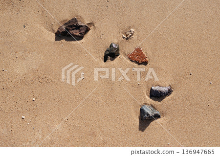 Sea stones on the sand. Beautiful tidal waves on the beach. Sandy beach of the Red Sea. Egypt. 136947665
