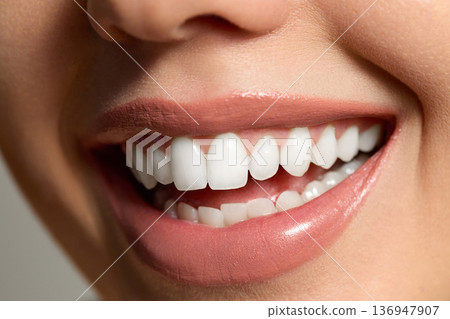 Skincare routine includes smiling woman showing her healthy teeth and skin at a bright spa location with natural light 136947907