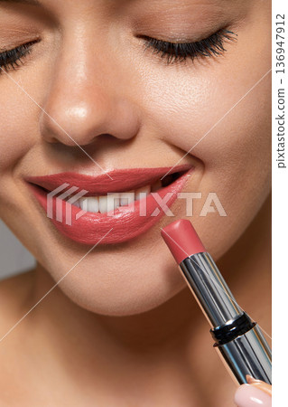 Closeup of woman applying lipstick during her skincare routine at home 136947912