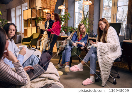 Modern comfortable office with team using laptops and tablets. 136948009