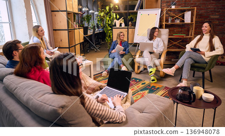 Startup team discussion in stylish loft workspace with laptops. Startup team discussion in stylish loft workspace with laptops. 136948078