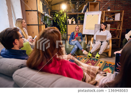 Casual team workshop in creative brick loft with flip chart. 136948083