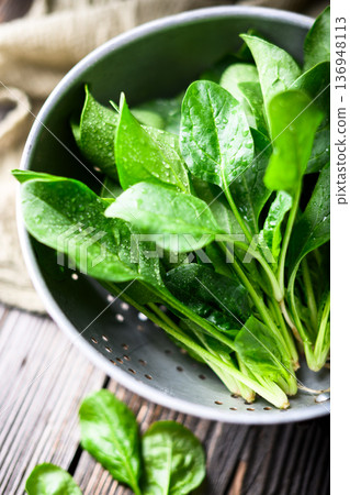 Wet baby spinach foliage draining in vintage metal colander Wet baby spinach foliage draining in vintage metal colander 136948113