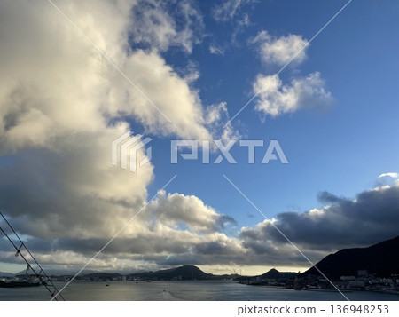 Land, white clouds and blue sky from a cruise ship Land, white clouds and blue sky from a cruise ship 136948253