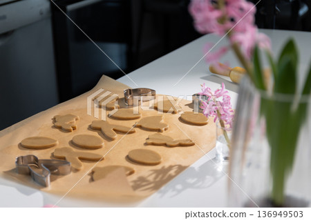 Preparing Festive Easter Gingerbread Bunny and Egg Cookies on Baking Paper Preparing Festive Easter Gingerbread Bunny and Egg Cookies on Baking Paper 136949503