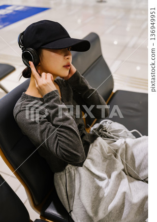 一位女士在機場聽音樂。照片由關西國際機場（KIX）提供。 136949951