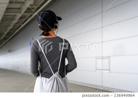 A woman listening to music with headphones. Photo courtesy of Kansai International Airport (KIX). A woman listening to music with headphones. Photo courtesy of Kansai International Airport (KIX). 136949964