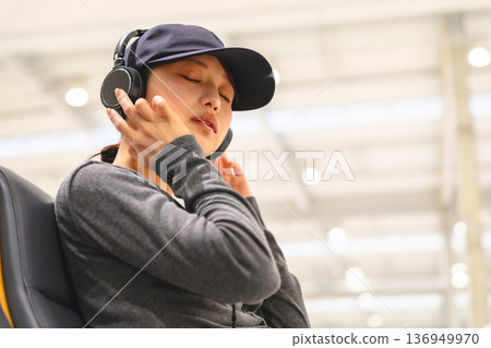 一位女士戴著耳機欣賞音樂。照片由關西國際機場（KIX）提供。 136949970