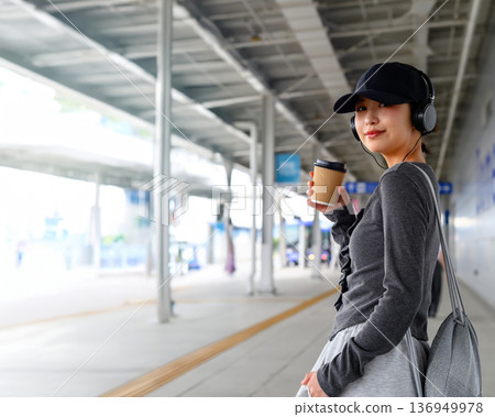 一位女士在車站聽音樂。照片由關西國際機場(KIX)提供。 一位女士在車站聽音樂。照片由關西國際機場(KIX)提供。 136949978