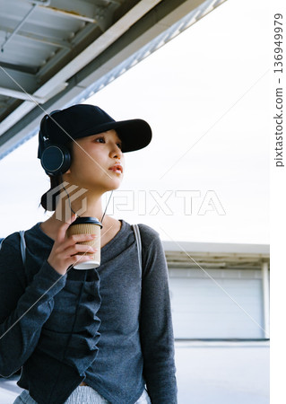 一位女士手持耳機和一杯咖啡。照片由關西國際機場（KIX）提供。 136949979