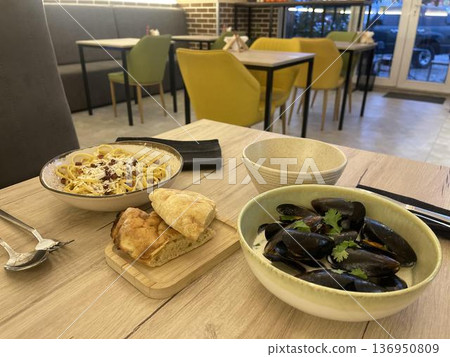 a bowl of musselins and a bowl of carbonara on a table a bowl of musselins and a bowl of carbonara on a table 136950809