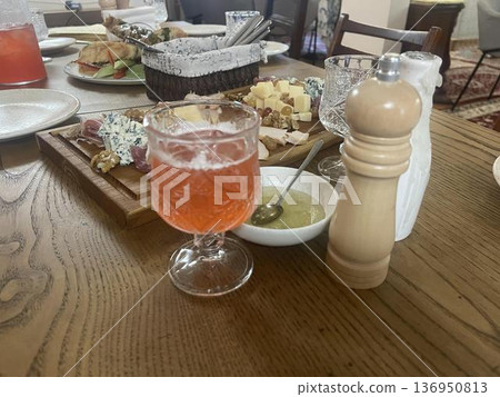 a table with a glass of wine and a plate of cheese a table with a glass of wine and a plate of cheese 136950813