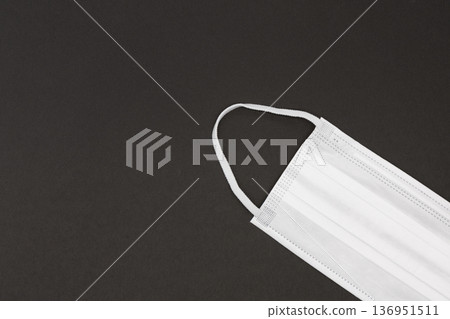 一個乾淨的白色不織布口罩放置在黑色背景上 136951511