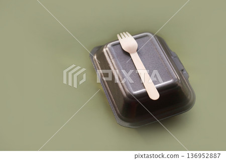 Minimal flat lay of disposable food box and wooden fork on soft olive backdrop, environmentally friendly dining idea 136952887