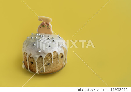 Festive Easter dessert with bunny topper and glossy icing on yellow background, cheerful seasonal styling with copy space Festive Easter dessert with bunny topper and glossy icing on yellow background, cheerful seasonal styling with copy space 136952961